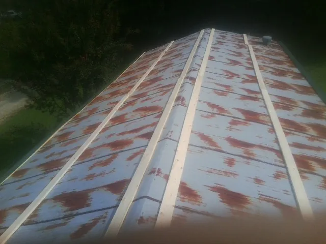 Rusted metal roof panels with new wood purlins before replacement — Storm Damage Roof Repair in Little Cedar by Roofing Brothers