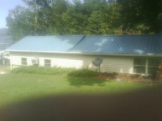 Blue metal roof running the length of a single story home in Little Cedar